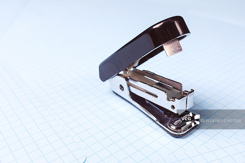 白色背景上的黑色订书机，桌面上的学校和办公用品，留白区域，学校和学前教育理念，办公室工作，工作场所特写图片素材