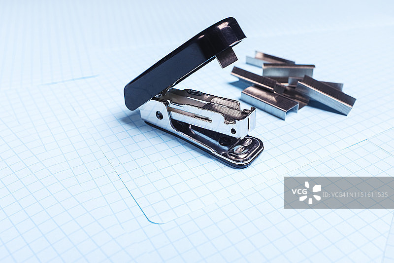 白色背景上的黑色订书机和订书钉图片素材