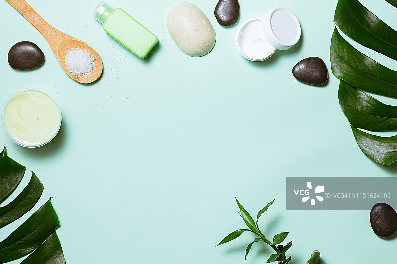 俯视水疗护肤品、竹子、沐浴盐、面霜和毛巾在柔和背景上图片素材