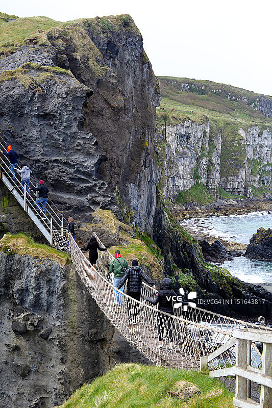 访客走过北爱尔兰的卡里克索桥图片素材