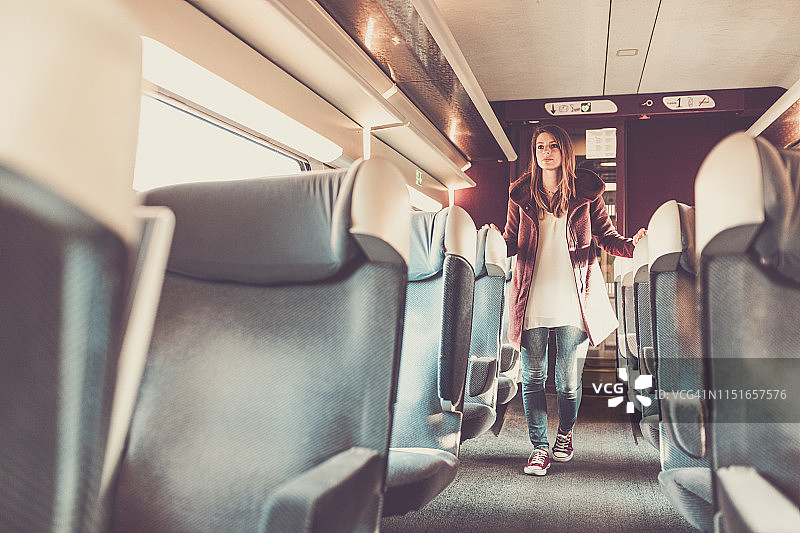年轻女人走在法国巴黎TGV列车的座位间图片素材