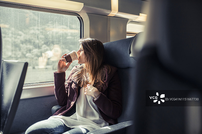 年轻女人在法国巴黎TGV列车上喝热饮图片素材