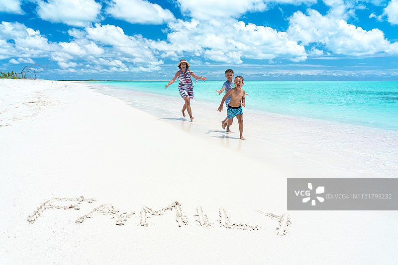 母亲和儿子在加勒比粉色沙滩上快乐玩耍图片素材