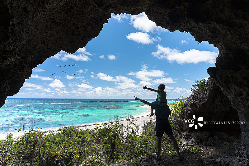 父子在加勒比海巴布达岛双脚湾海蚀洞图片素材