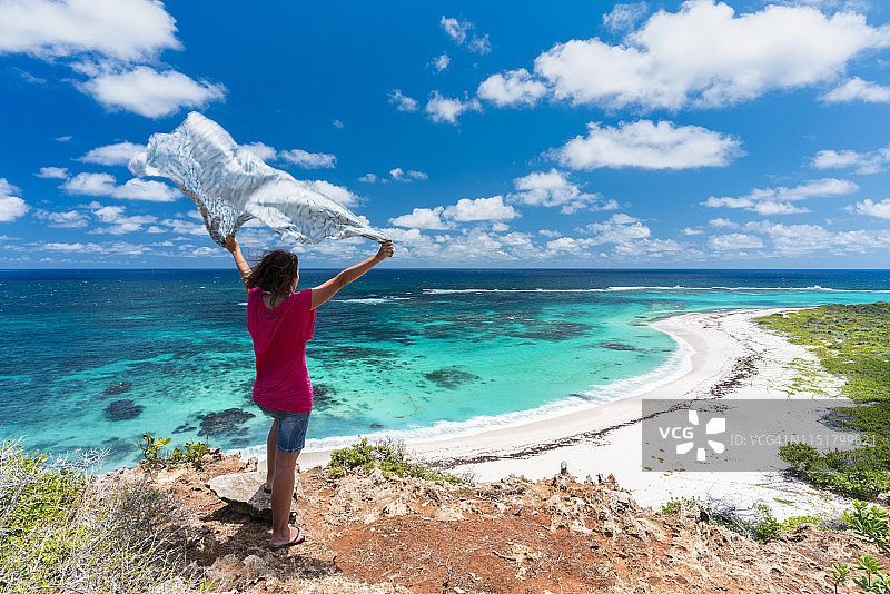 女人在加勒比海挥舞纱笼欣赏大海图片素材