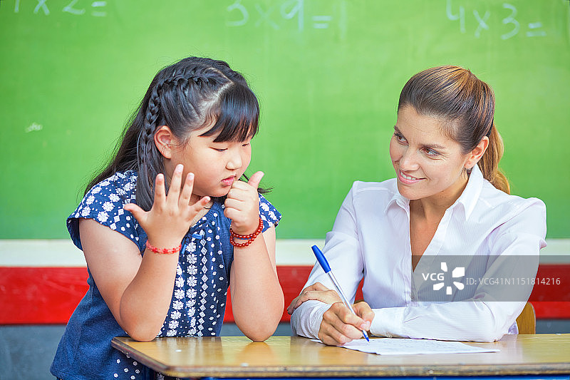 教育理念：返校季。数学课上的老师和女学生图片素材