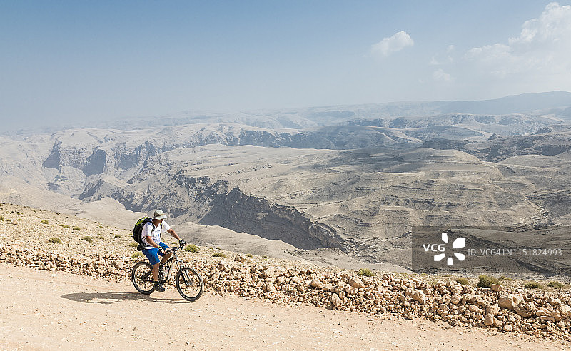 在阿曼哈杰尔山脉高处的孤独山地自行车手图片素材