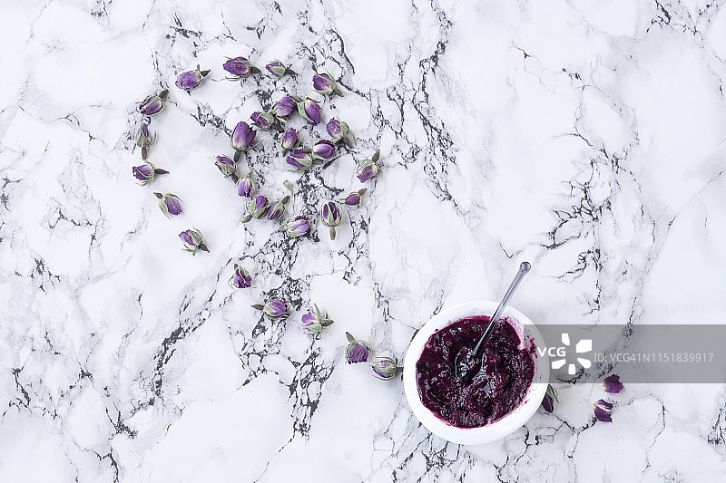 白色碗中搭配冻干玫瑰的野生浆果冰淇淋，白色大理石桌面背景，俯视角度及复制空间图片素材