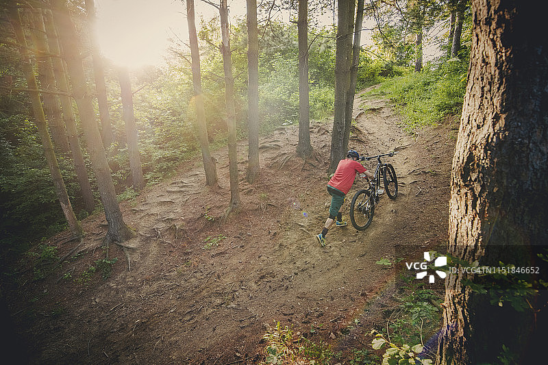 骑自行车的人在森林里扛着山地自行车图片素材