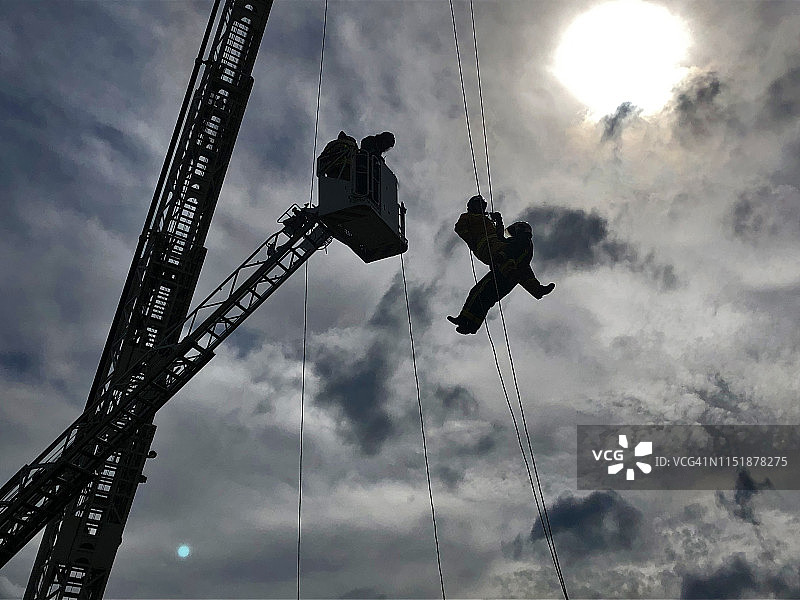 美丽多云天空背景下的高层消防救援人员工作图片素材