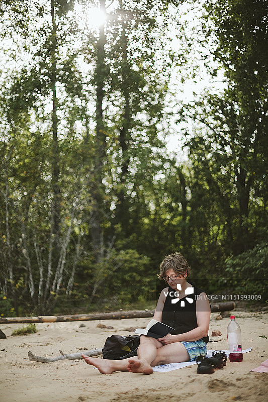 在沙滩上看书的女人图片素材