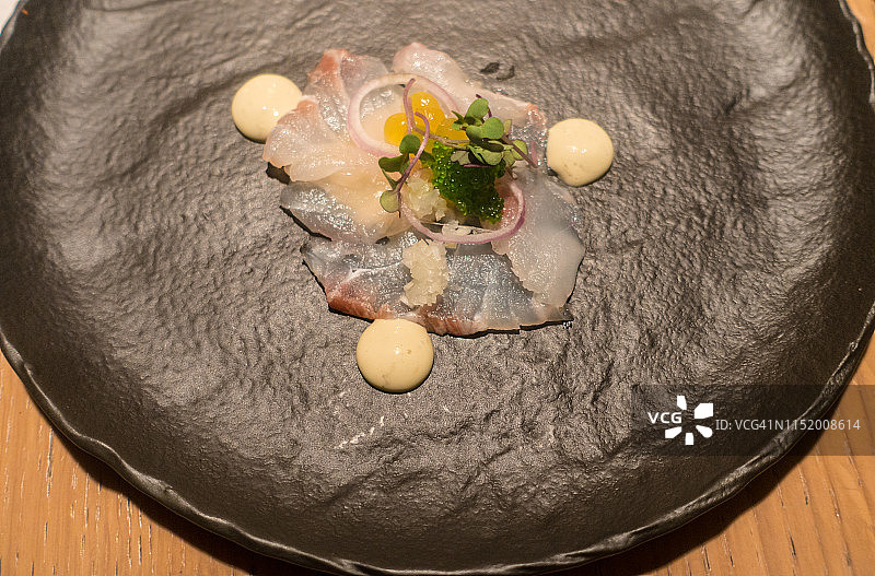 灰色盘子上的美洲牙鳕（海鳟鱼），西班牙比斯开省毕尔巴鄂图片素材