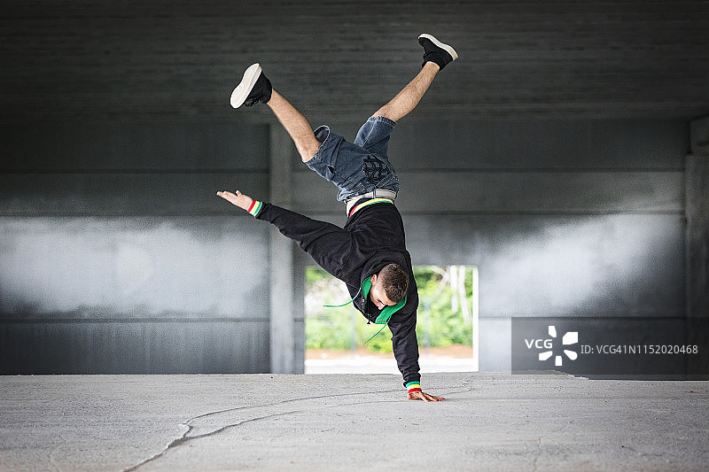 在工业大厅里跳霹雳舞的年轻男子图片素材