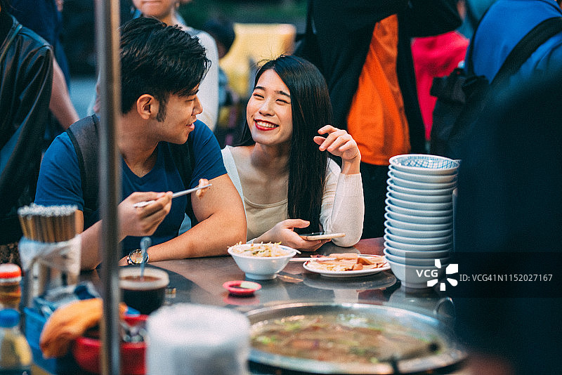 中国台湾台北夜市里享受街头美食的年轻亚洲夫妇图片素材