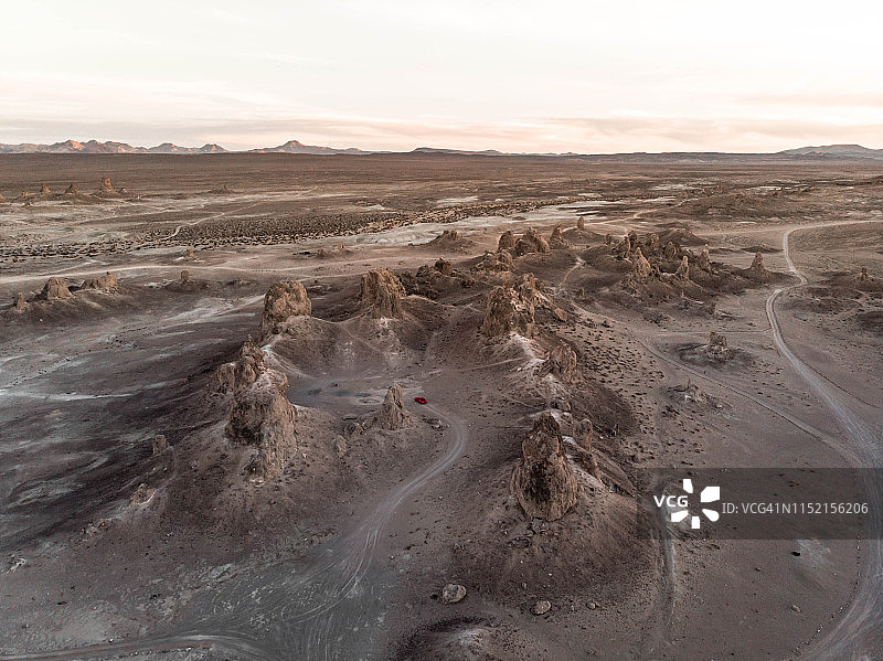 无人机视角下美国汽车行驶在加州沙漠的岩层中图片素材