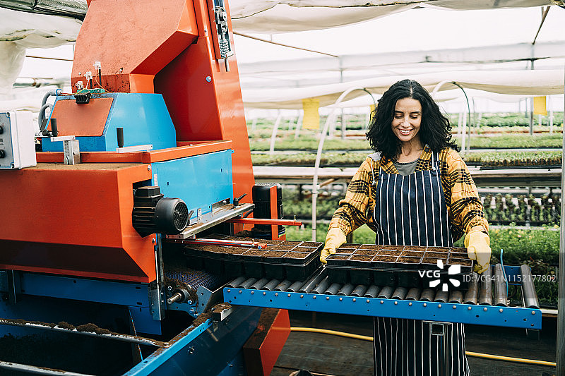 园艺中心工人使用土壤撒布机图片素材