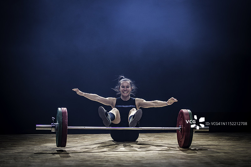 笑容满面的笨拙年轻女举重运动员图片素材