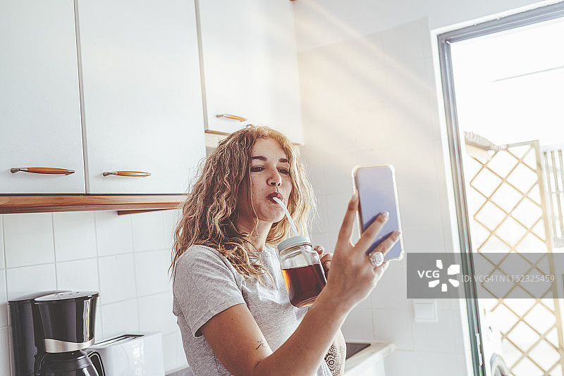 在厨房使用智能手机的女人图片素材