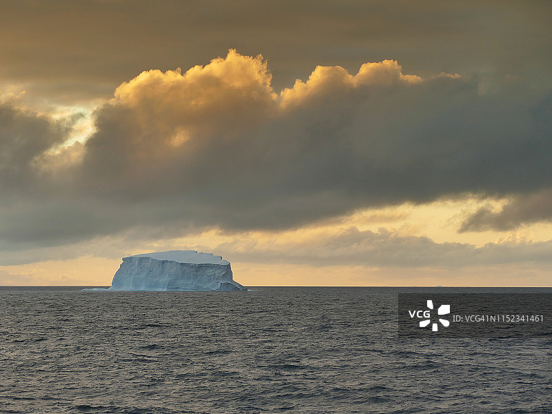 南极洲南大洋日落时分戏剧性天空下的远处冰山图片素材