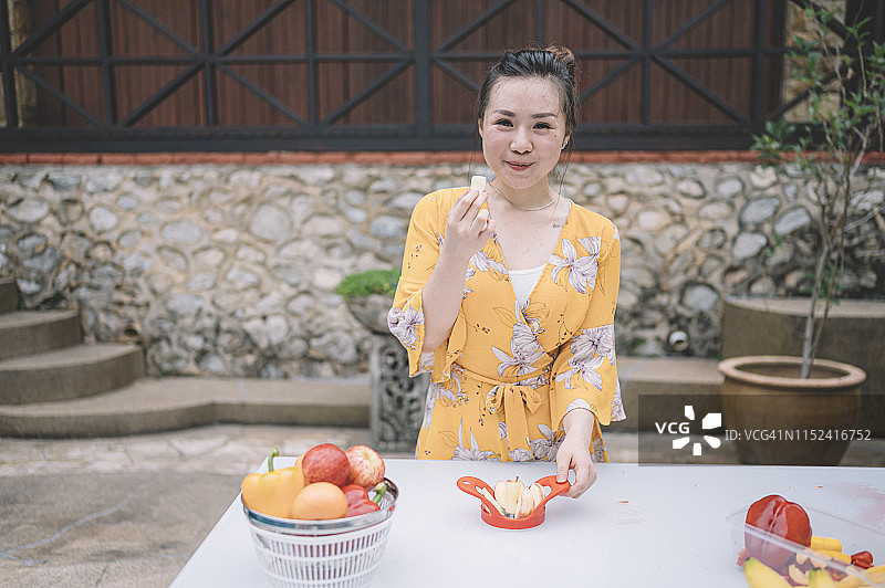 亚洲女性度假村外用取核器切苹果图片素材