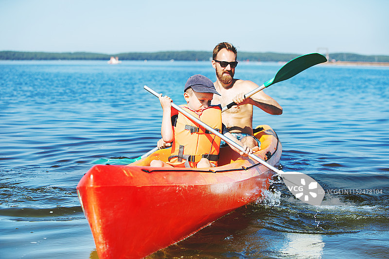 父子在湖上划皮划艇图片素材