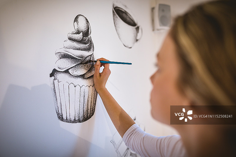 年轻女艺术家画巧克力麦芬图片素材