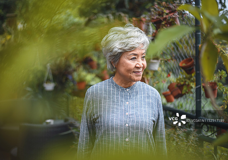 笑容满面的老年妇女在后院眺望远方图片素材