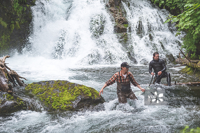阿拉斯加渔民在瀑布旁用渔网捕鱼图片素材