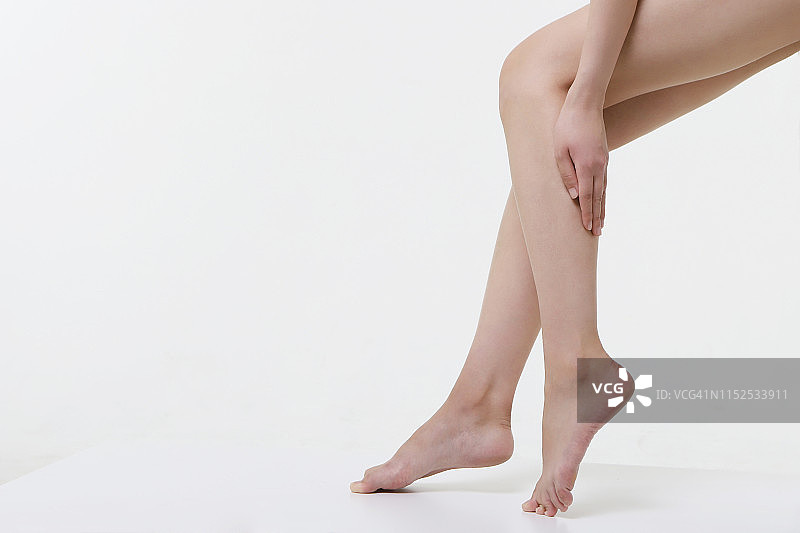 年轻女人触摸腿图片素材