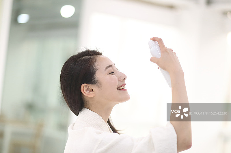 年轻女人喷洒水雾图片素材