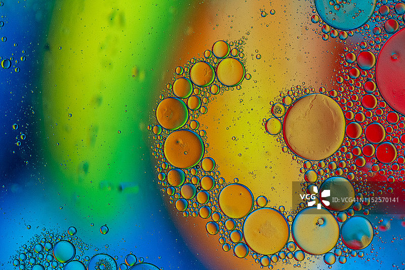 漂浮在水面上的油滴形成彩色抽象圆圈图片素材