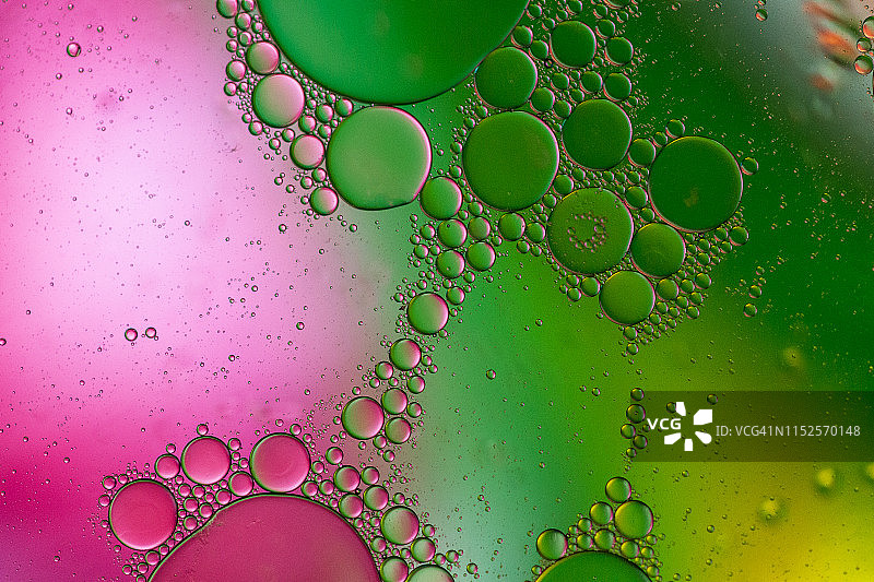 漂浮在水面上的油滴形成彩色抽象圆圈图片素材