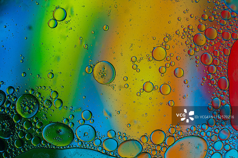 漂浮在水面上的油滴形成彩色抽象圆圈图片素材
