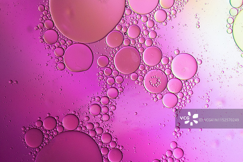 漂浮在水面上的油滴形成彩色抽象圆圈图片素材