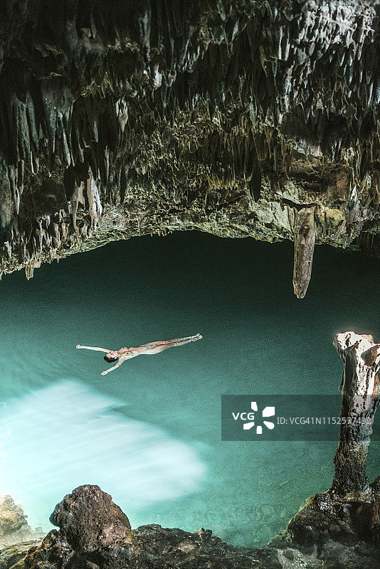 女人在弗洛勒斯岛的洞穴中游泳图片素材