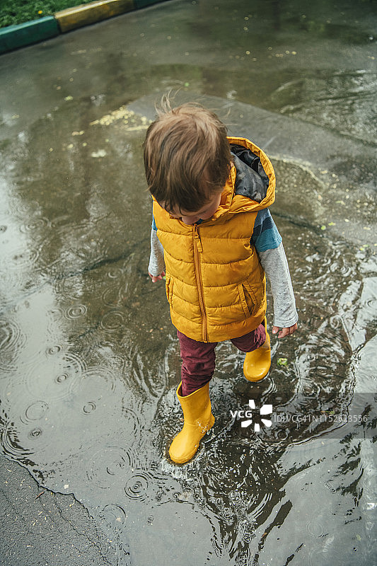 可爱小男孩雨天玩耍图片素材