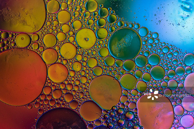 漂浮在水面上的油滴形成彩色抽象圆圈图片素材