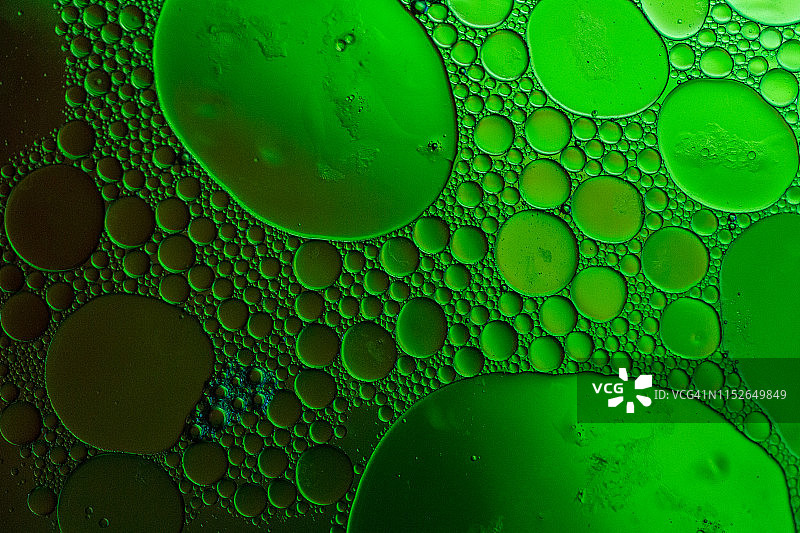 漂浮在水面上的油滴形成彩色抽象圆圈图片素材