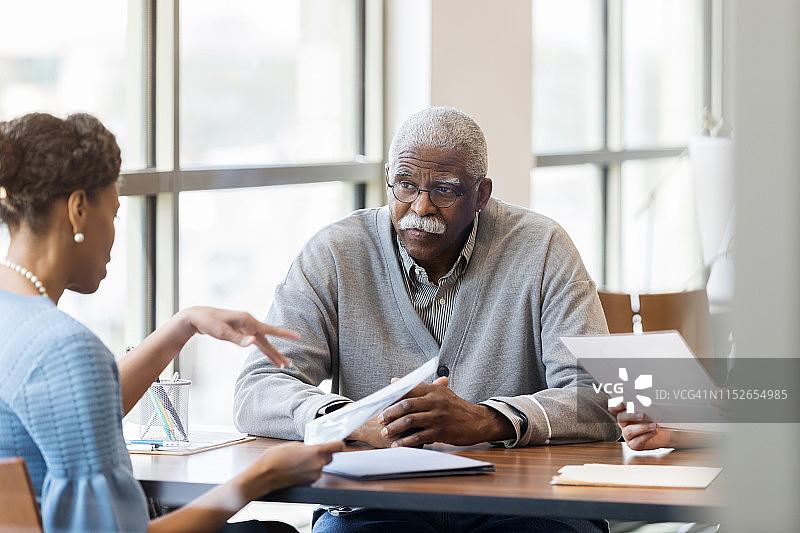 女信贷员与年长男人交谈图片素材