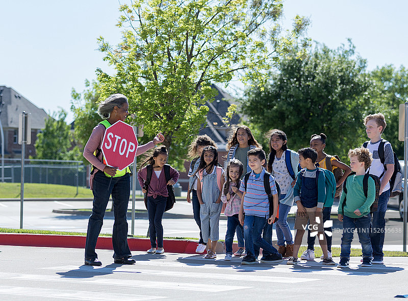 交通协管员带领学生过马路图片素材