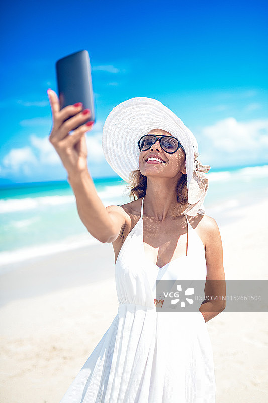 在海滩参加视频会议的可爱女人图片素材