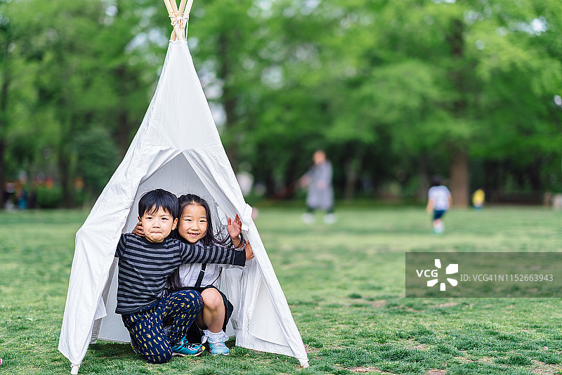 兄妹在公园帐篷里玩耍图片素材