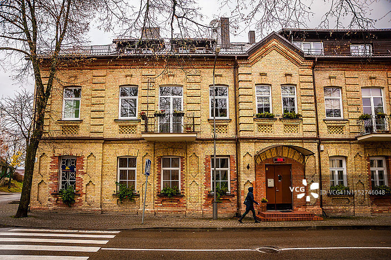 男人在小镇的老式住宅前行走图片素材