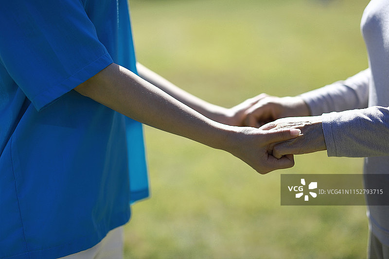 护士与老年妇女手牵着手图片素材