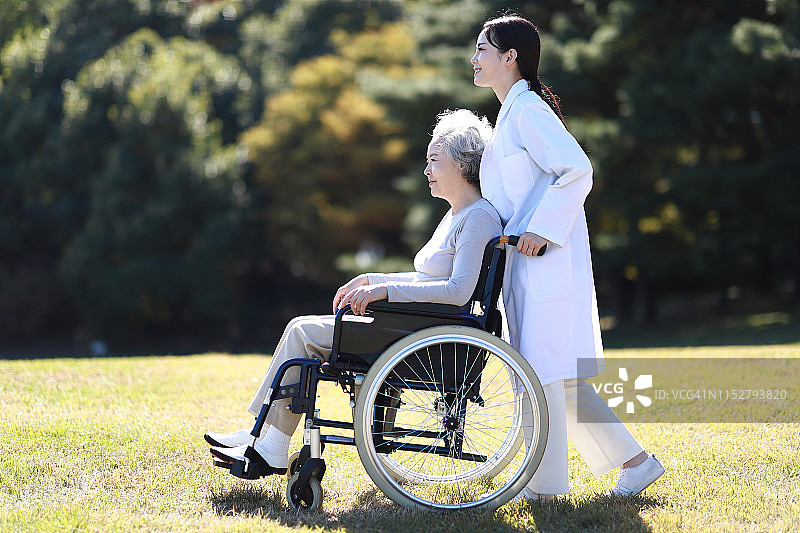 医生推着坐轮椅的老年女人图片素材