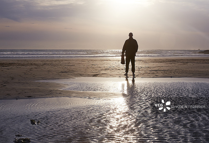 北德文海滩日落时分的男子剪影图片素材