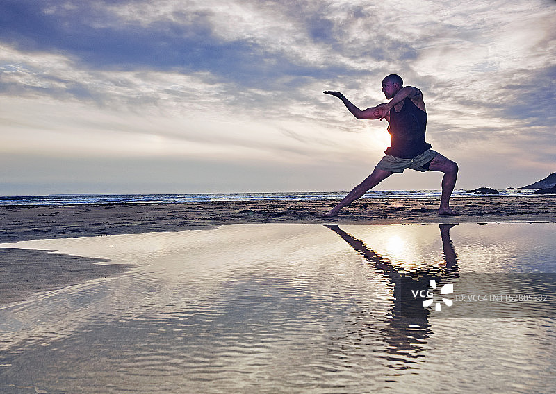 男人在海滩上练习功夫的剪影图片素材