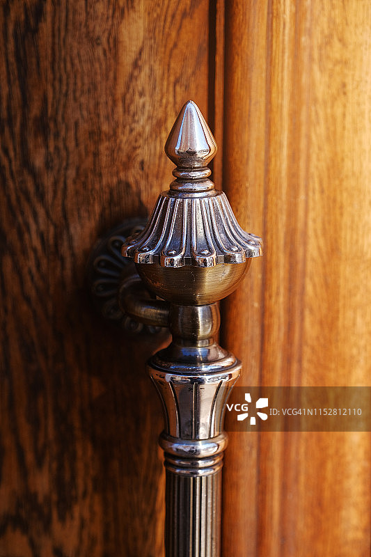 带扭曲铁把手的精美木制前门竖版特写图片素材