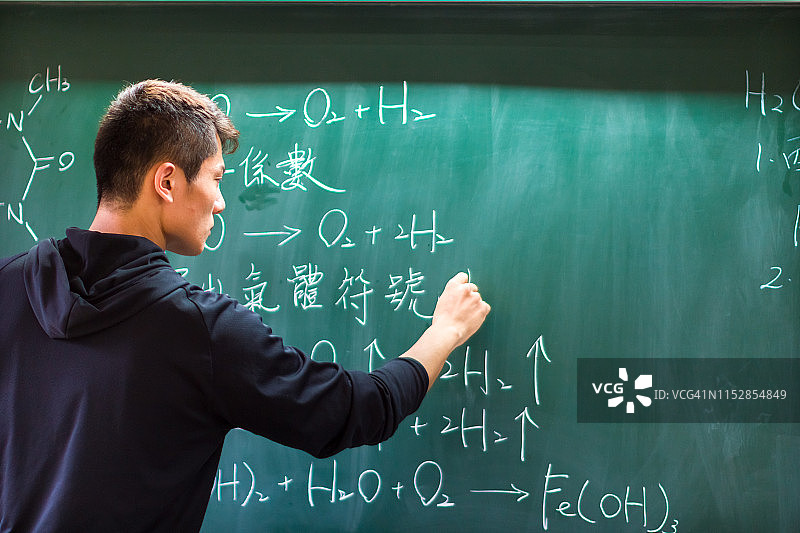 亚洲大学生在黑板上解化学方程式图片素材