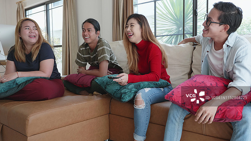 年轻千禧一代在公寓客厅一起看电视图片素材